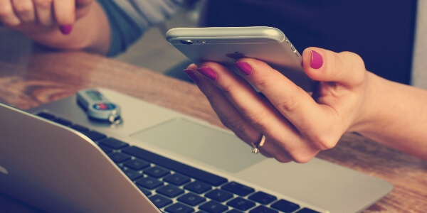 woman checking her electronic medical records on a laptop and smartphone