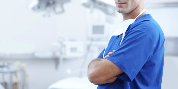 doctor stands arms folded in a hospital room considering indemnity insurance changes