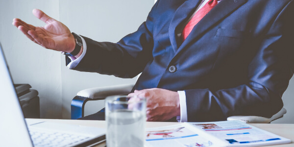 an insurance broker sits at his desk, explaining how a top up health plan can help you