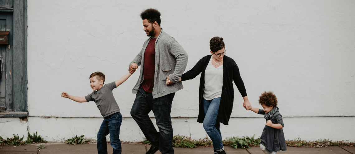 an expat family holding hands