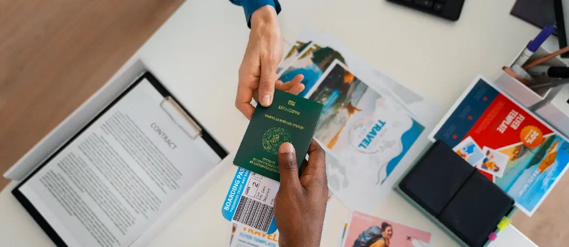 A person handing their passport with boarding pass to another person