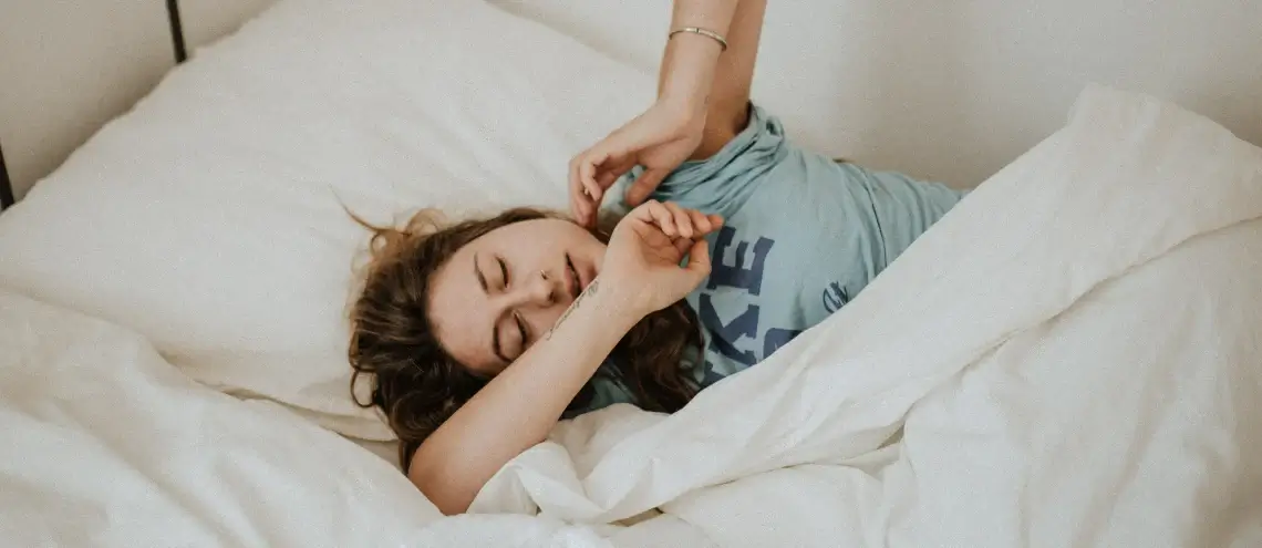 A woman scratching her body on a bed