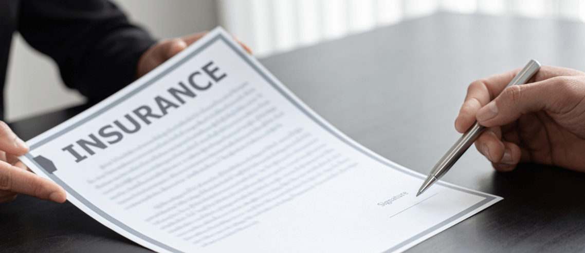 a man signing an insurance contact with the salesperson